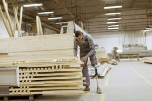 Amputado de extremidad inferior trabajando en fábrica